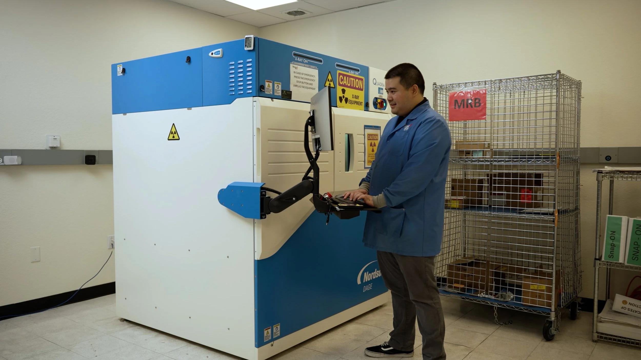 Omega GTI technician operating a Nordson DAGE X-ray inspection system in the test and inspection lab
